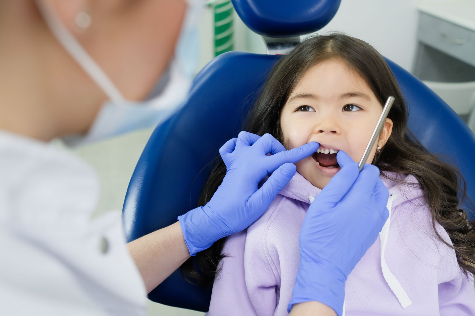     Young girl smiling while receiving dental care